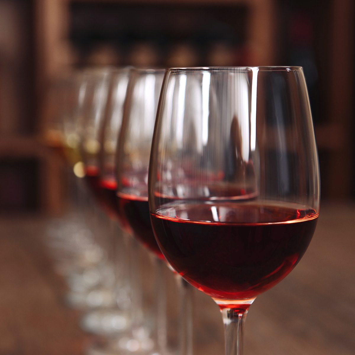 Many glasses of different wine in a row on bar counter