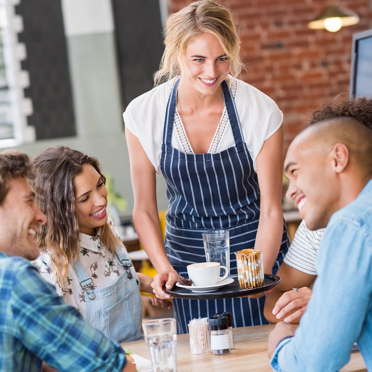 Happy smiling waitress serving food to a young happy group of friends in a cafeteria. Waitress serving on tray coffee to customers. Happy woman serving capuccino to group of multiethnic students.; Shutterstock ID 505366549; Job (TFH, TOH, RD, BNB, CWM, CM): Taste of Home