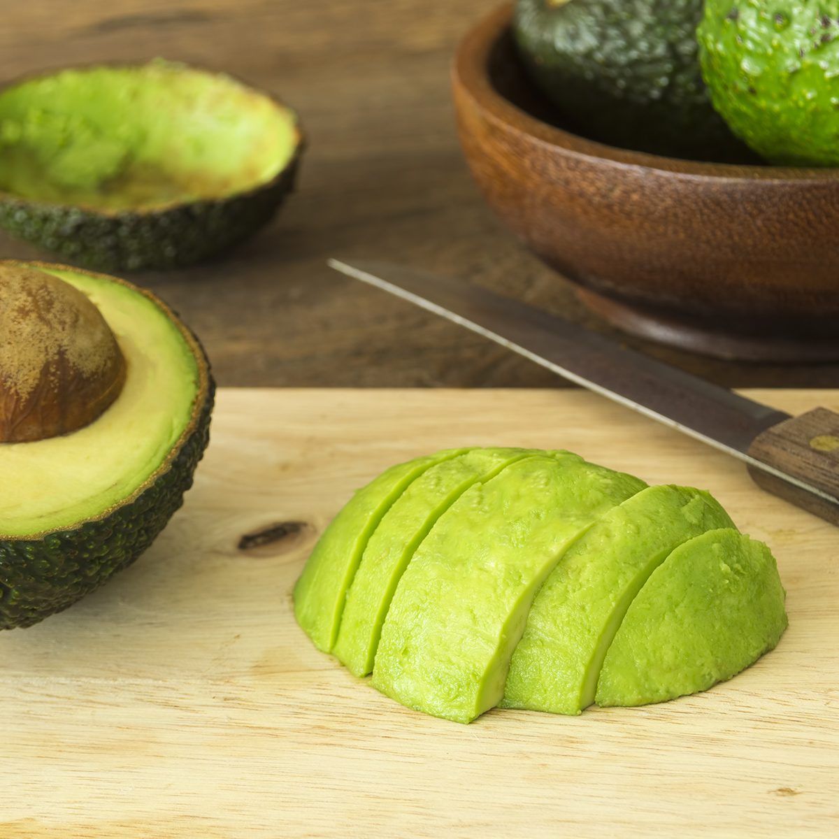 fruits for diabetics avocado and Sliced avocado slices on wooden board