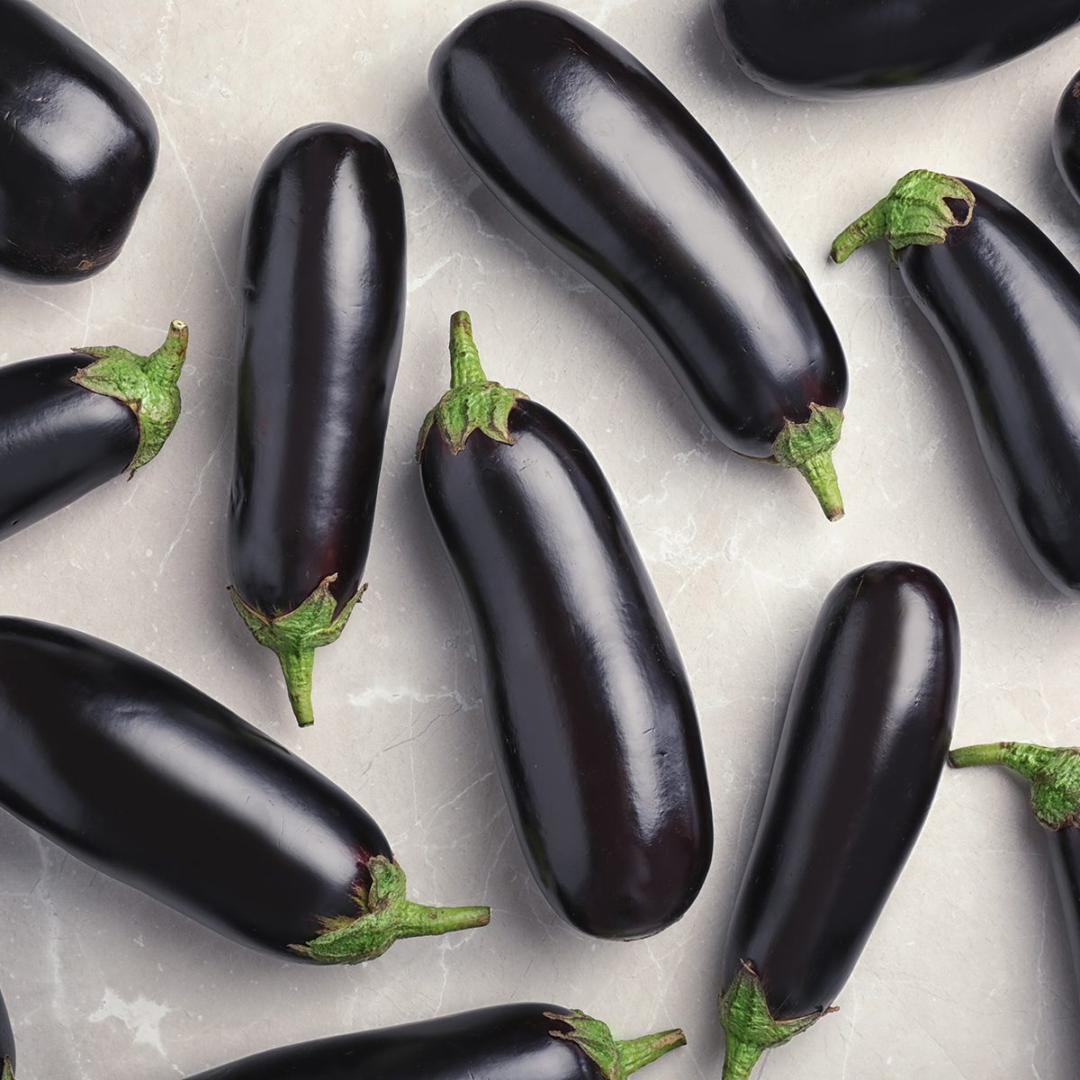 Raw ripe eggplants on light background