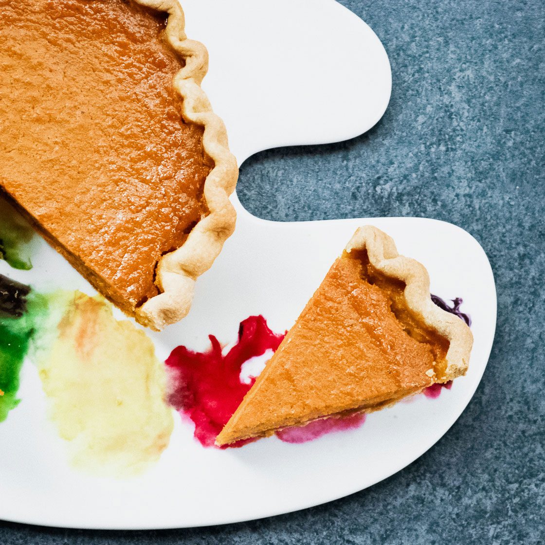 slice of sweet potato pie on a plate that looks like a paint palette