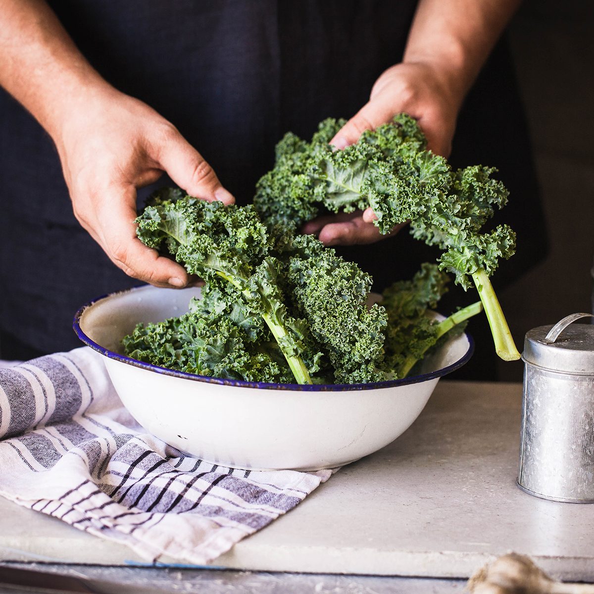 Kale leafy greens vegetable box hold in hands wash black wall raw kale ready to prepare food hand greens leafy