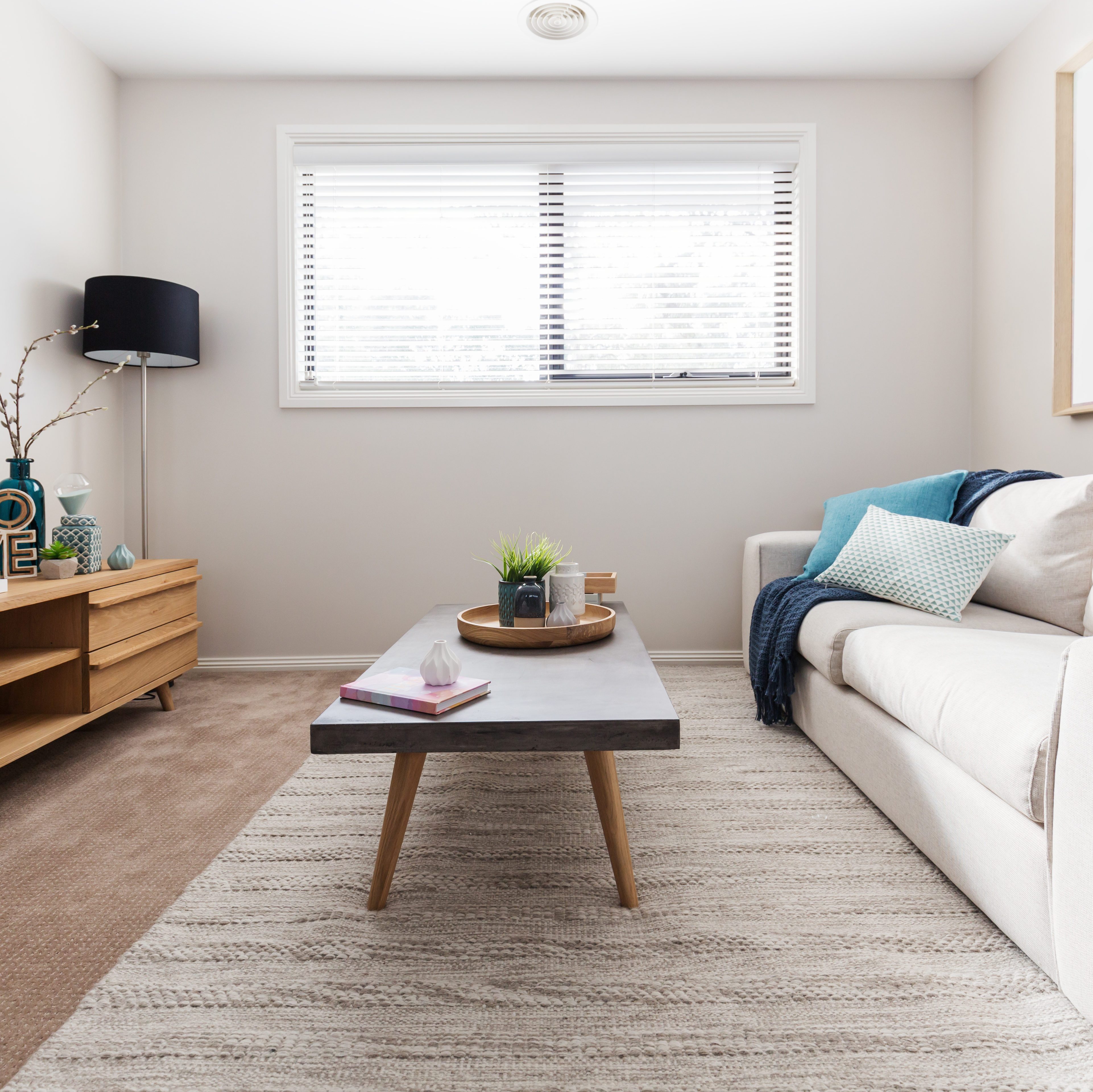 White room with white sofa and wood table