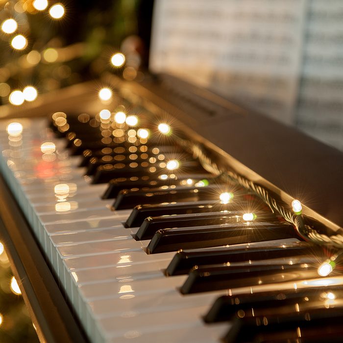 A piano with christmas lights and tree