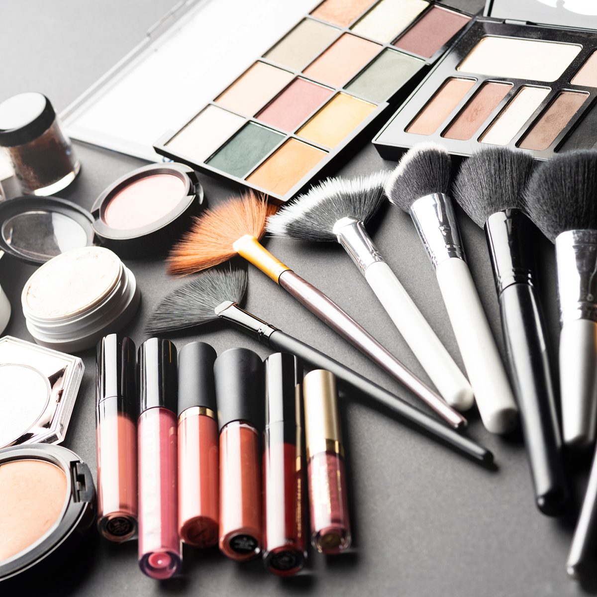 Multiple cosmetic products on black background. High resolution image for cosmetics and fashion industry.