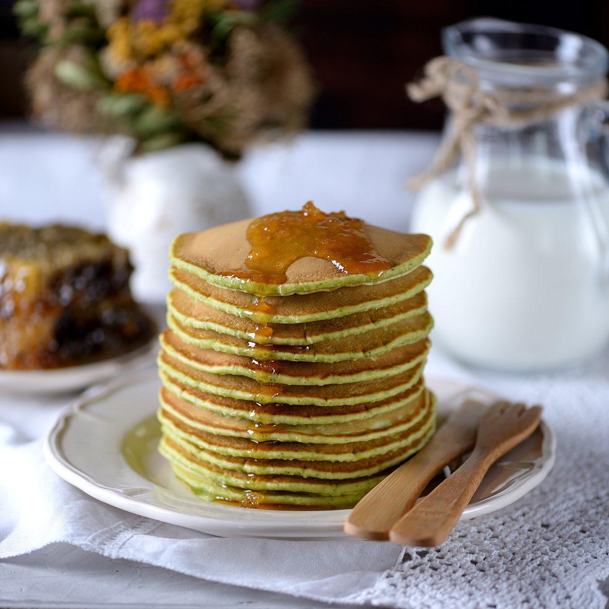 Spinach pancakes with milk and organic honey in honeycombs.