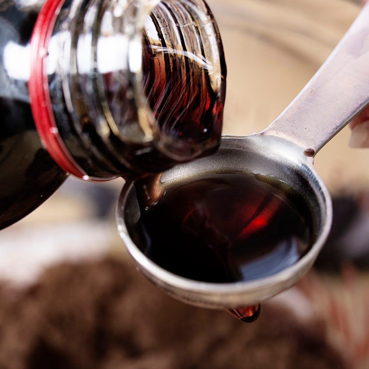 Close-up of vanilla extract being poured onto a teaspoon
