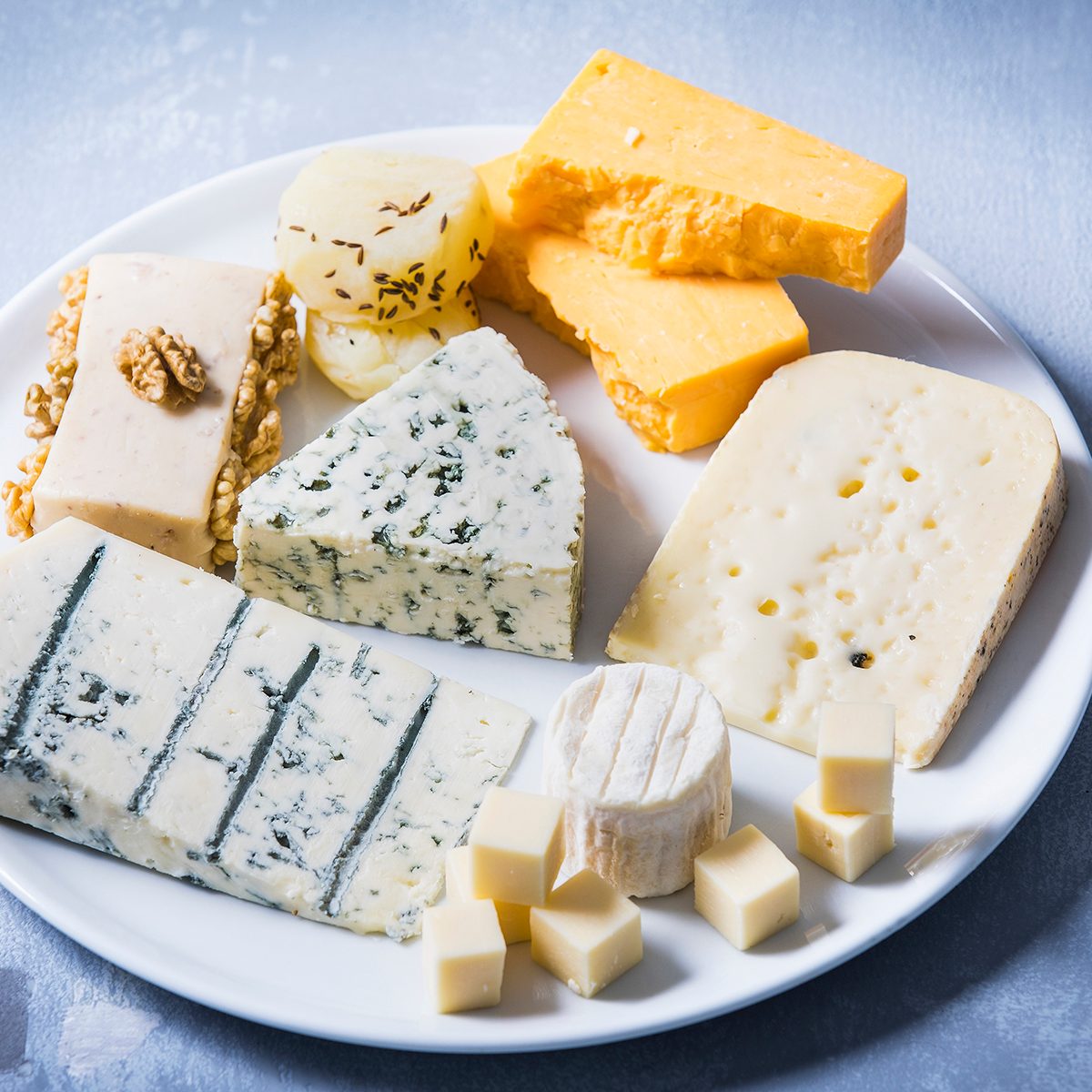 Käseplatte, Studio - Cheddar, Tete Moine, Gorgonzola, Ziegenkäse, französischer Schafkäse, Butterkäse, Schimmelkäse, Schmelzkäse mit Walnüssen, Pfefferkäse, Handkäse, Gouda, Parmigiano, Weintrauben, Walnüsse, Frühlingszwiebeln