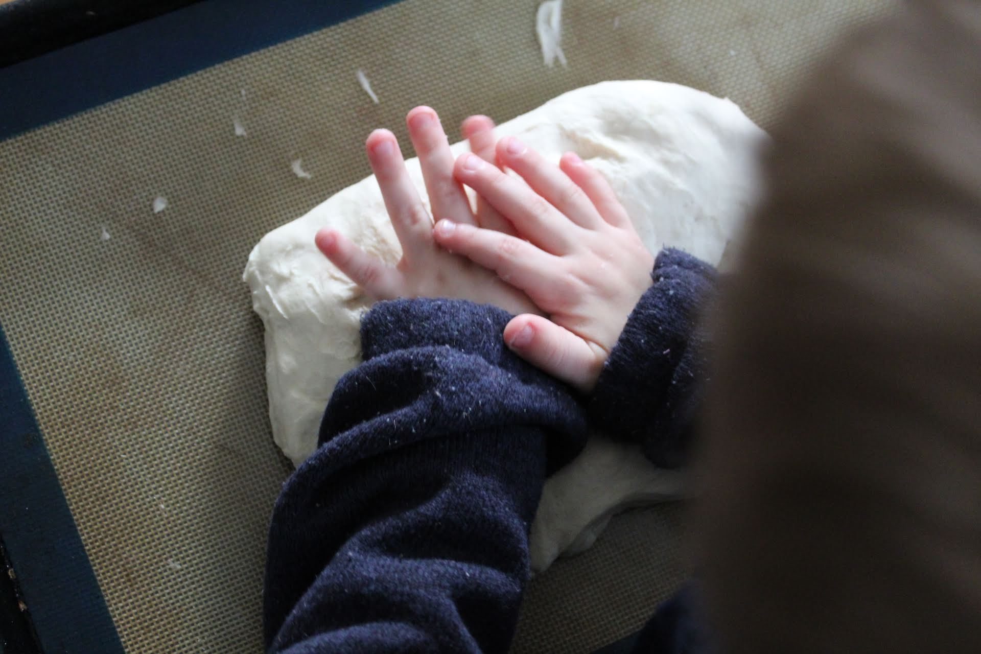 Child hands kneading dough