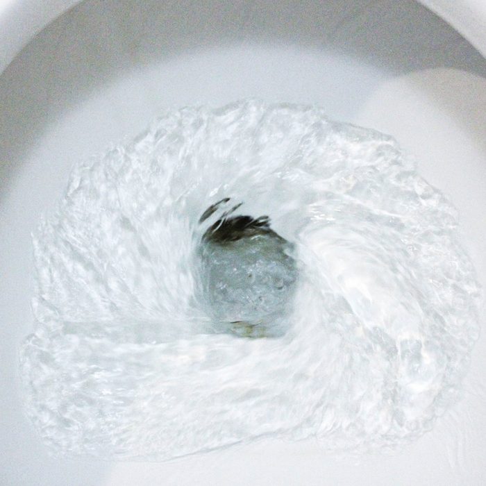 selective focus close up flushing toilet bowl for sanitary