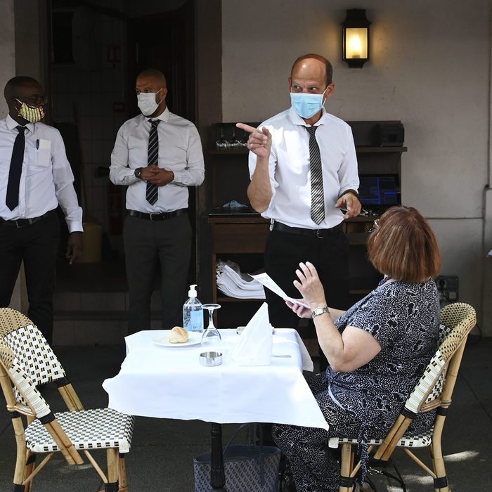 Woman talking to a masked waiter
