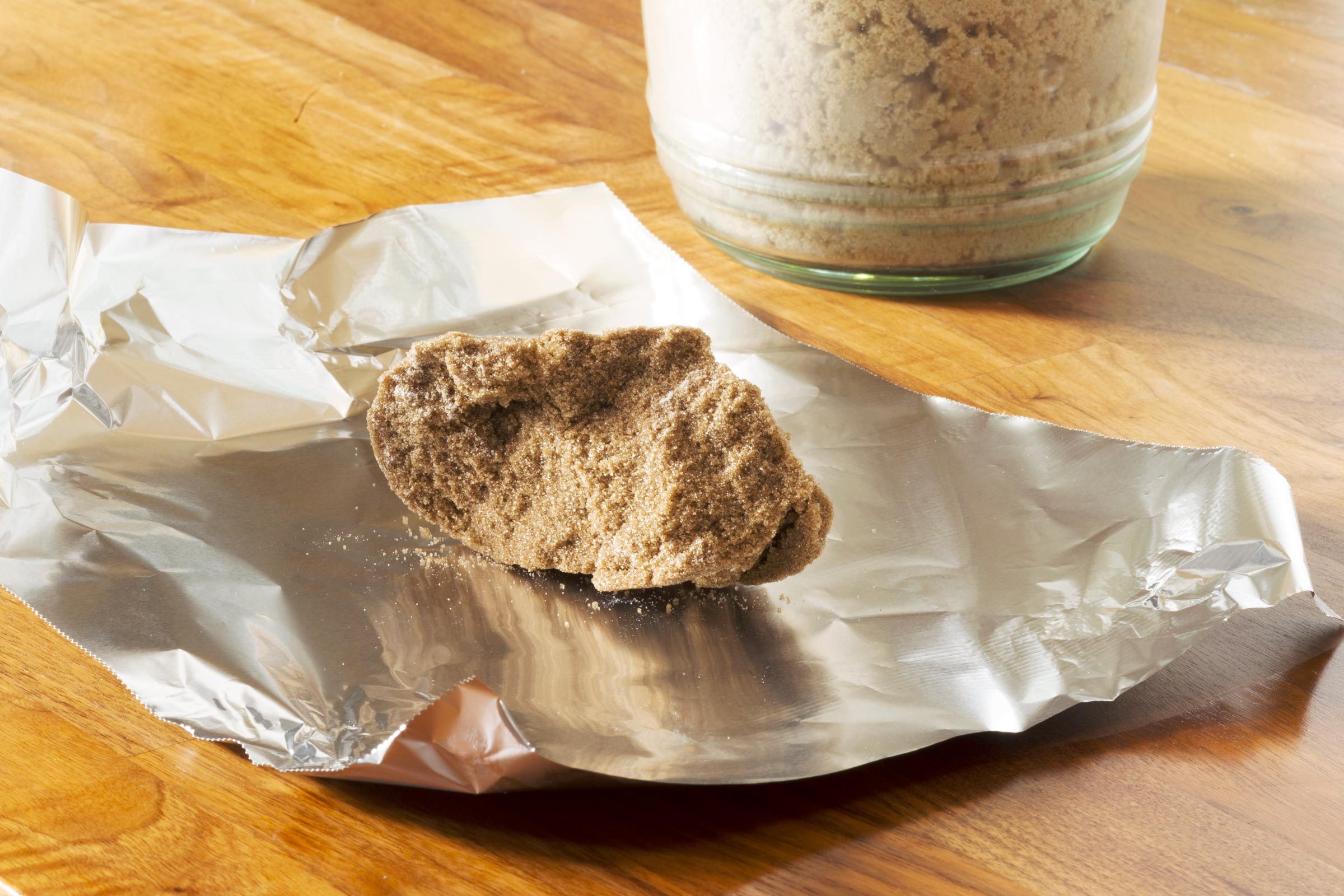 a clump of hard brown sugar on a piece of aluminum foil
