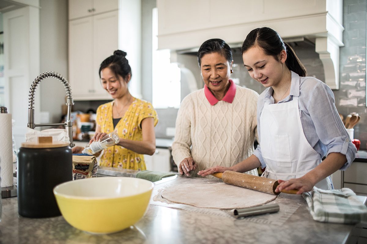 Grandmother, Granddaughter and mother cooking in kitchen