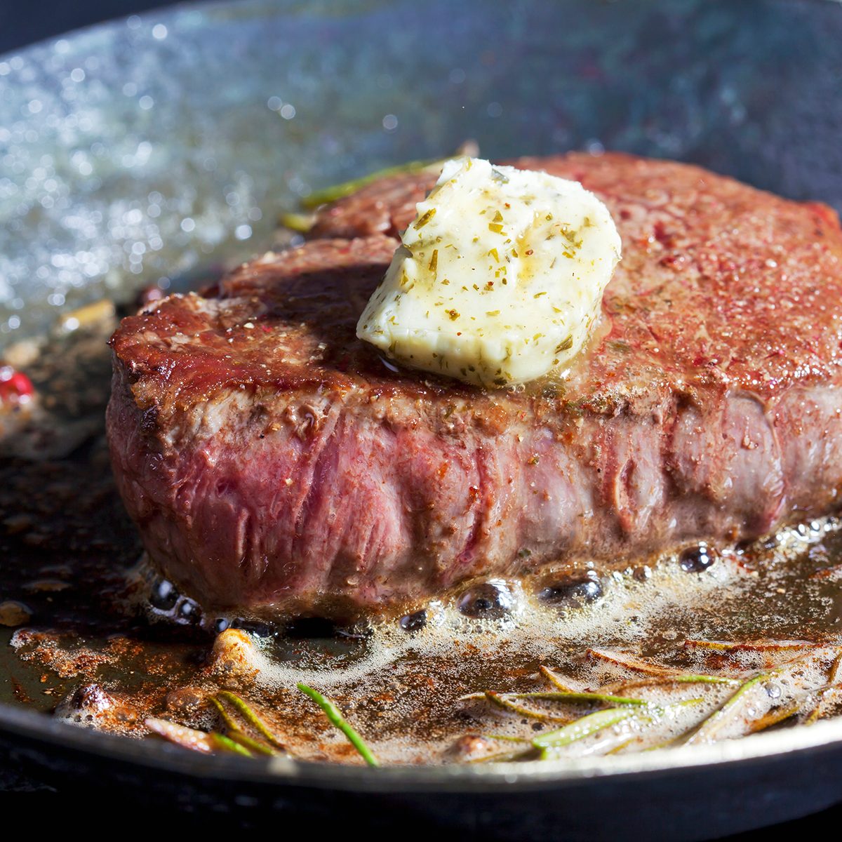 Gebratenes Rinderfilet, Medallion, Fleisch, Rindfleisch, dunkle Pfanne, Butter, Pfefferkörner, Rosmarin, Kräuterbutter, braten, Bläschen, schwarzer Untergrund