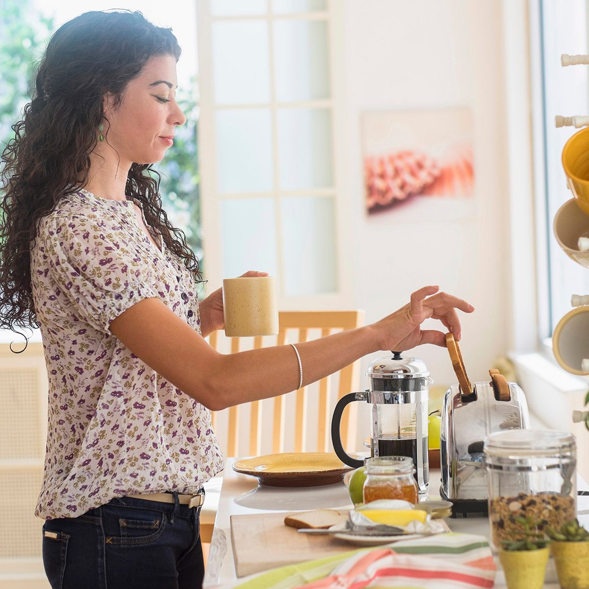Mixed race woman preparing breakfast in kitchen