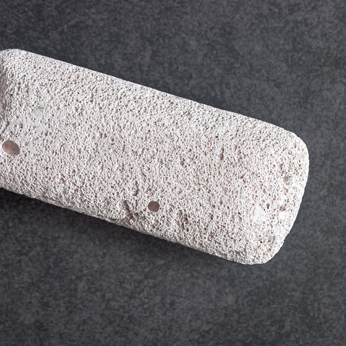 Raw pumice stone on table, light weight and with rough surface.