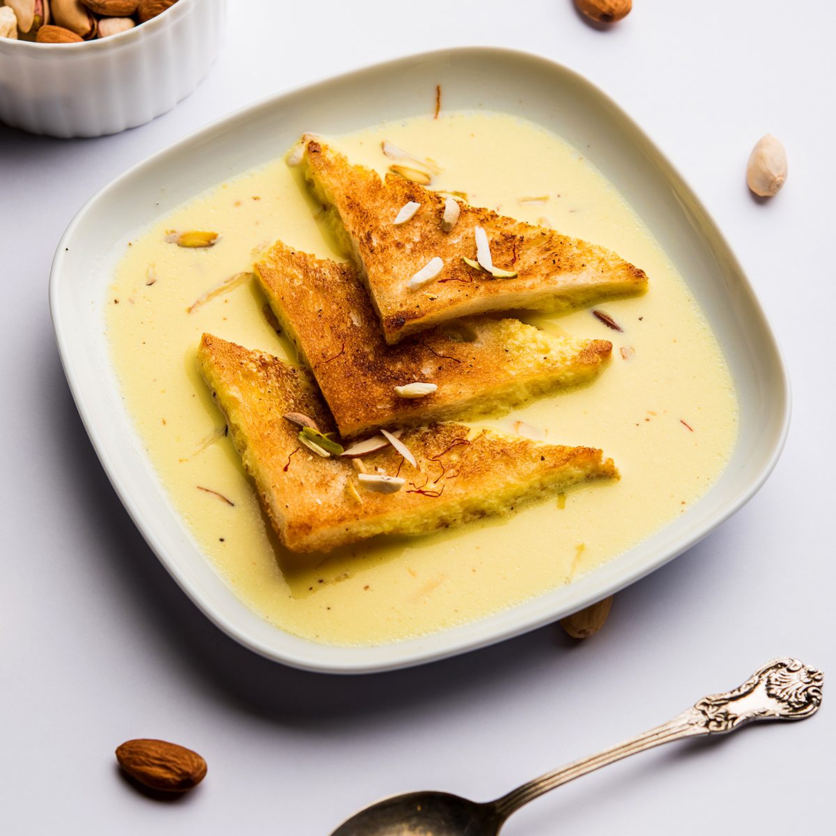 shahi tukra/tukda or Double ka meetha is a bread pudding Indian sweet of fried bread slices soaked in rabid or sweet saffron milk garnished with dry fruits, selective focus