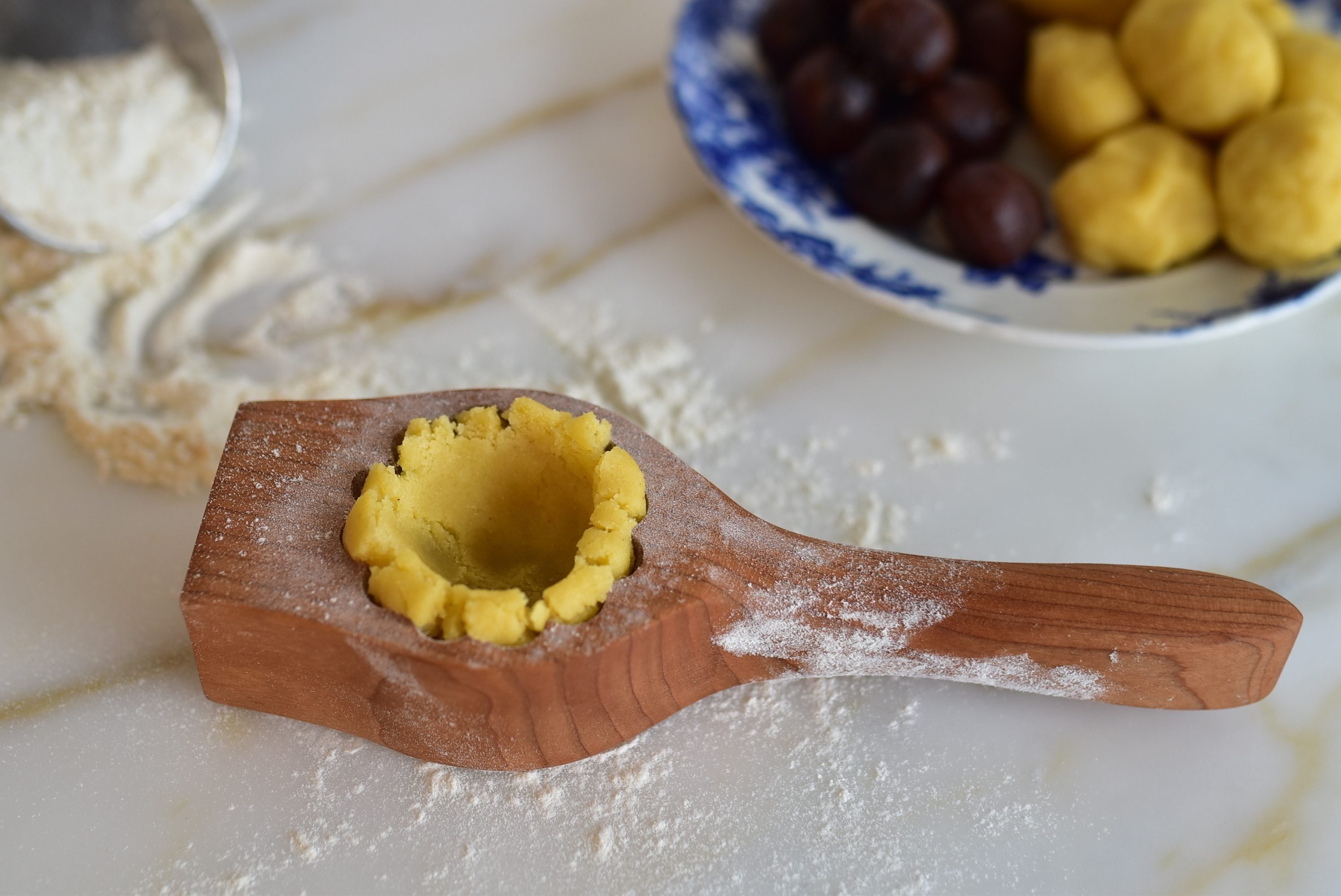Dough in a ma'amoul mold hollowed out for filling