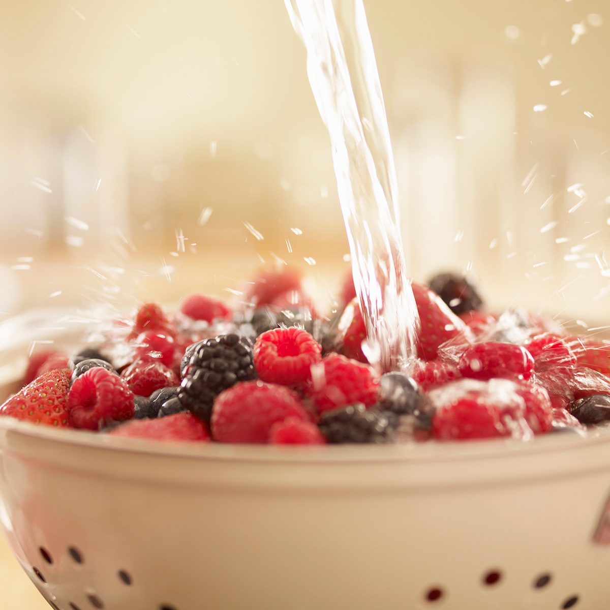 colander uses Water Splashing Over Berries In Colander
