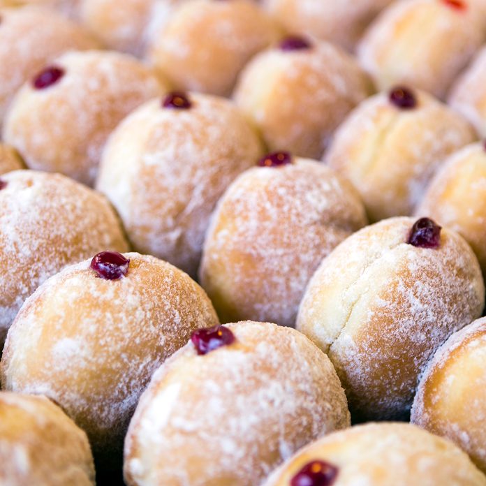 easter traditions around the world Jelly doughnuts on display in a bakery.
