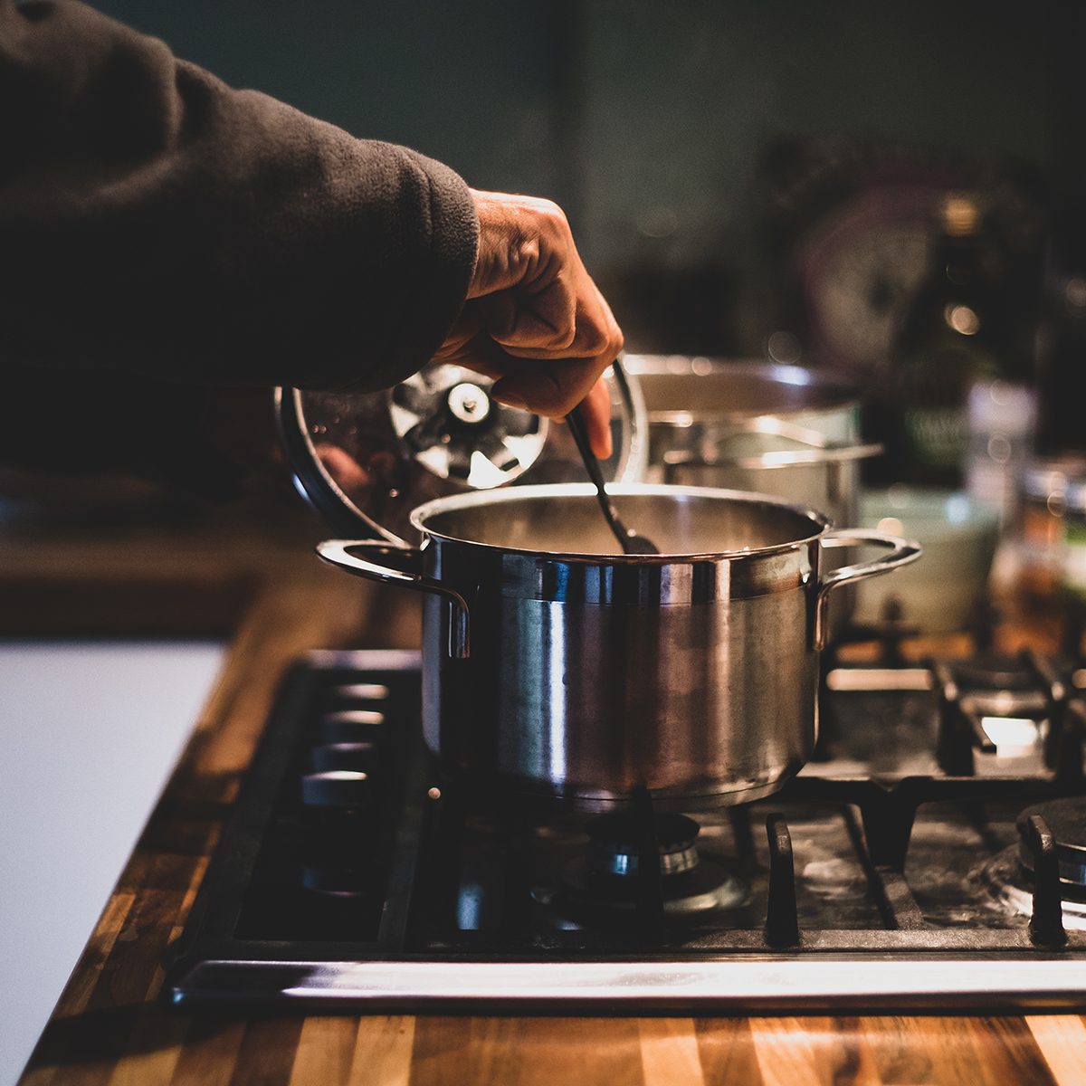 cheesecake factory secrets A man cooking at night, stirring the stew pan. People who eat home-cooked meals on a regular basis tend to be happier and healthier.