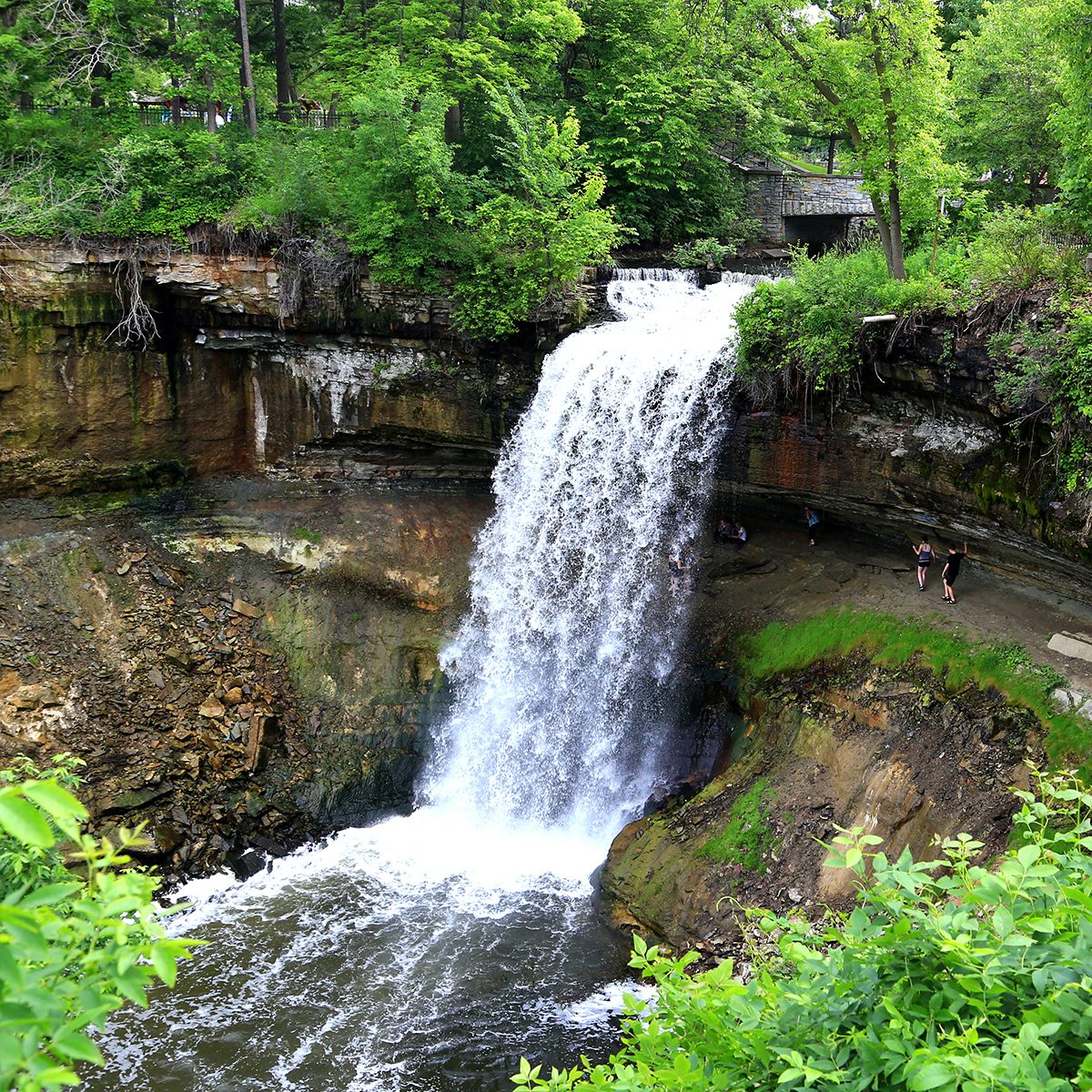 Tourists stand behind the Minnehaha Falls on the Minnehaha River, Minnehaha Park, Minneapolis, Hennepin County, Minnesota, Midwest, United States