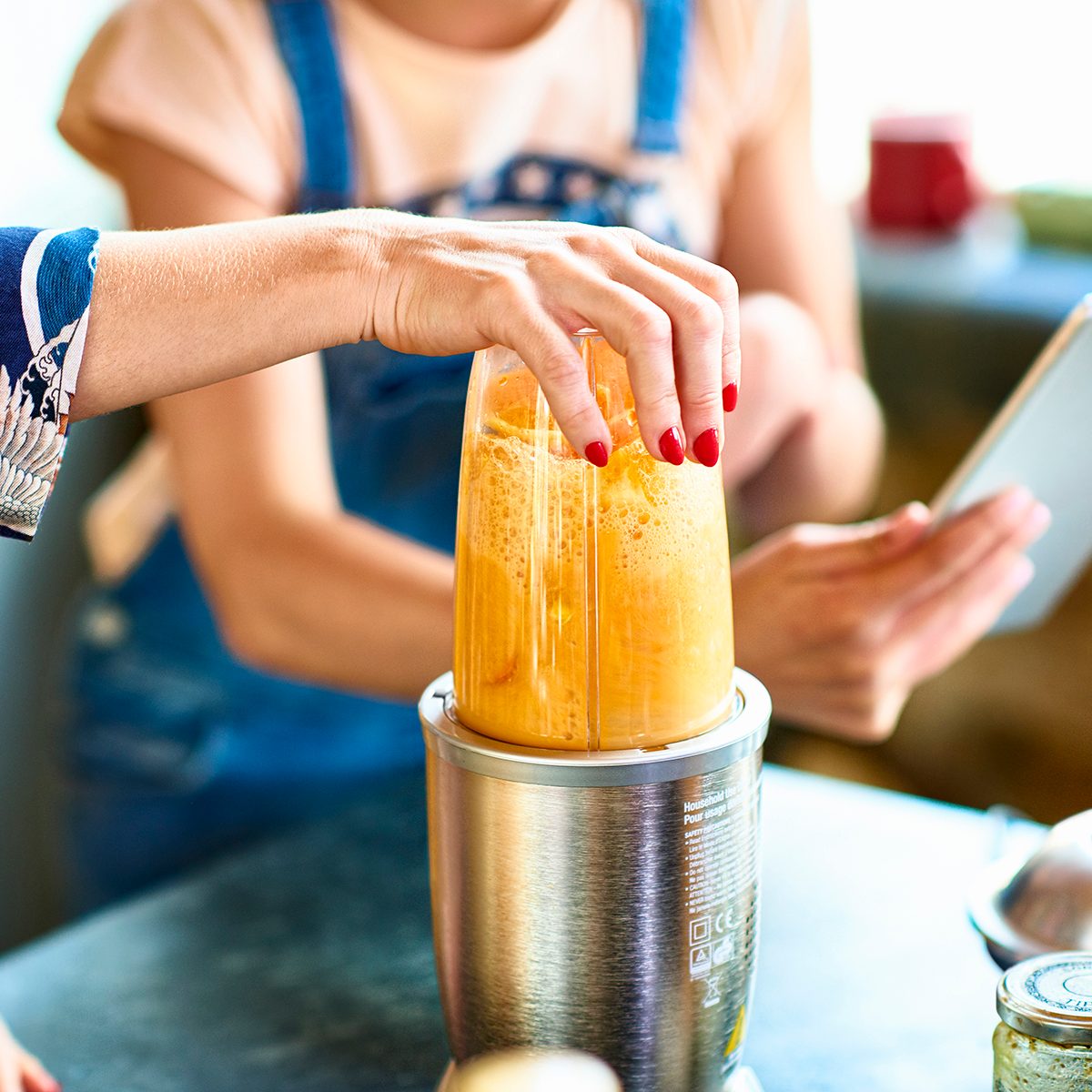 how to make frozen drinks Woman Preparing Smoothie In Blender