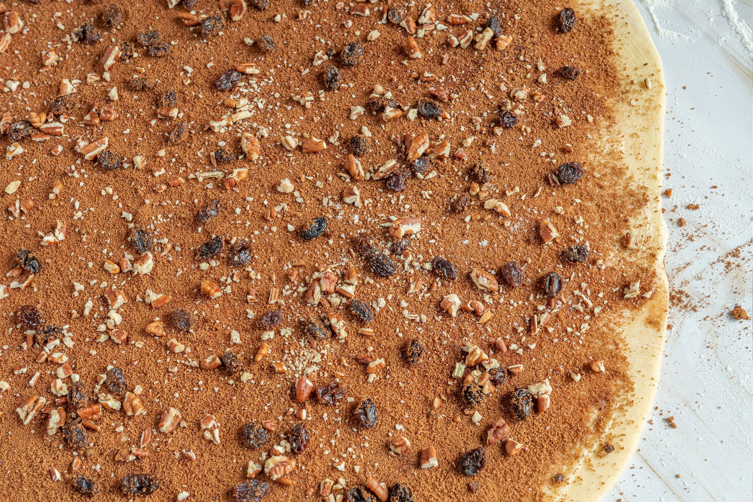 rolled out dough with filling spread on top for domino sugar cinnamon rolls