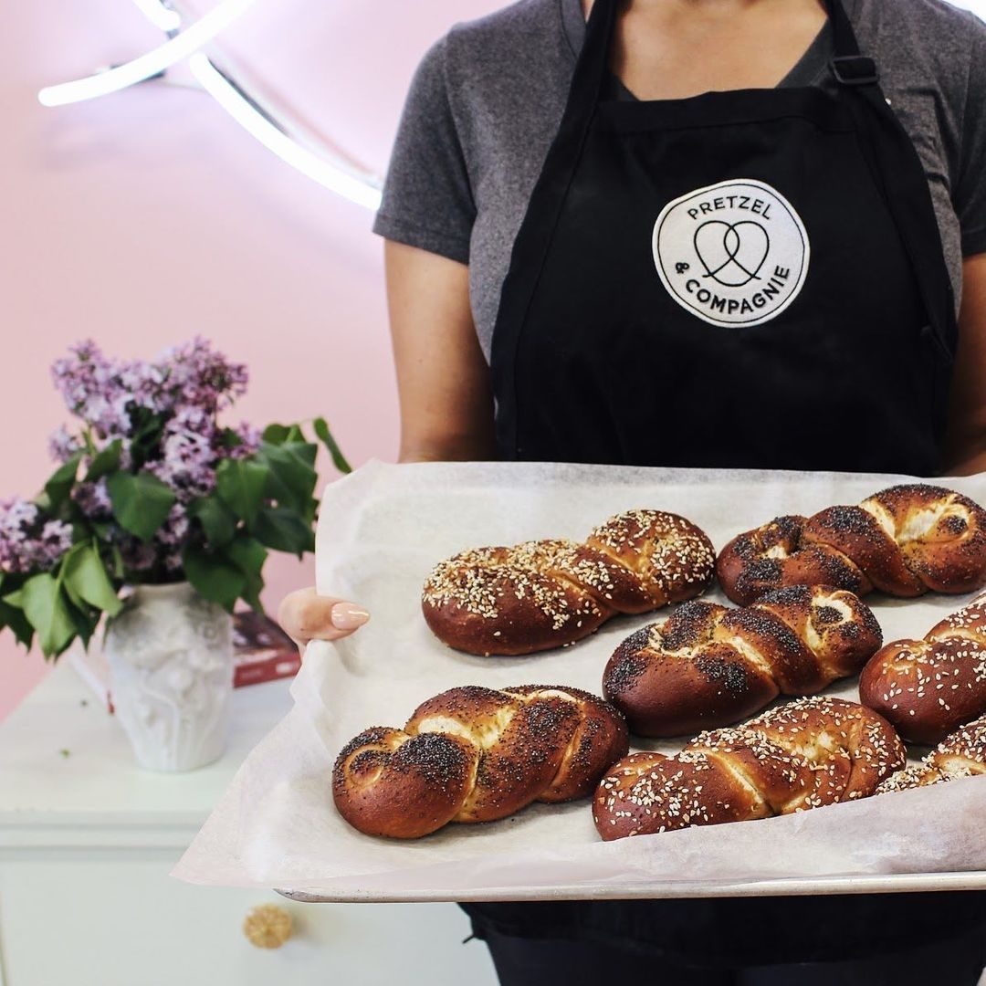 Anonymous woman wearing an apron holding a tray of Stuffed Pretzel Braids