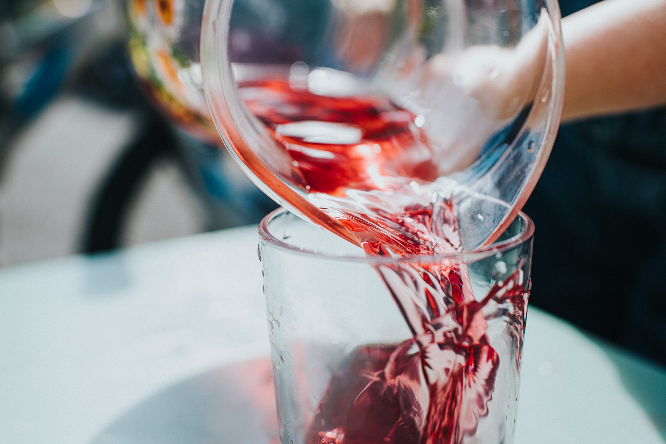 pouring red fruit juice into glass