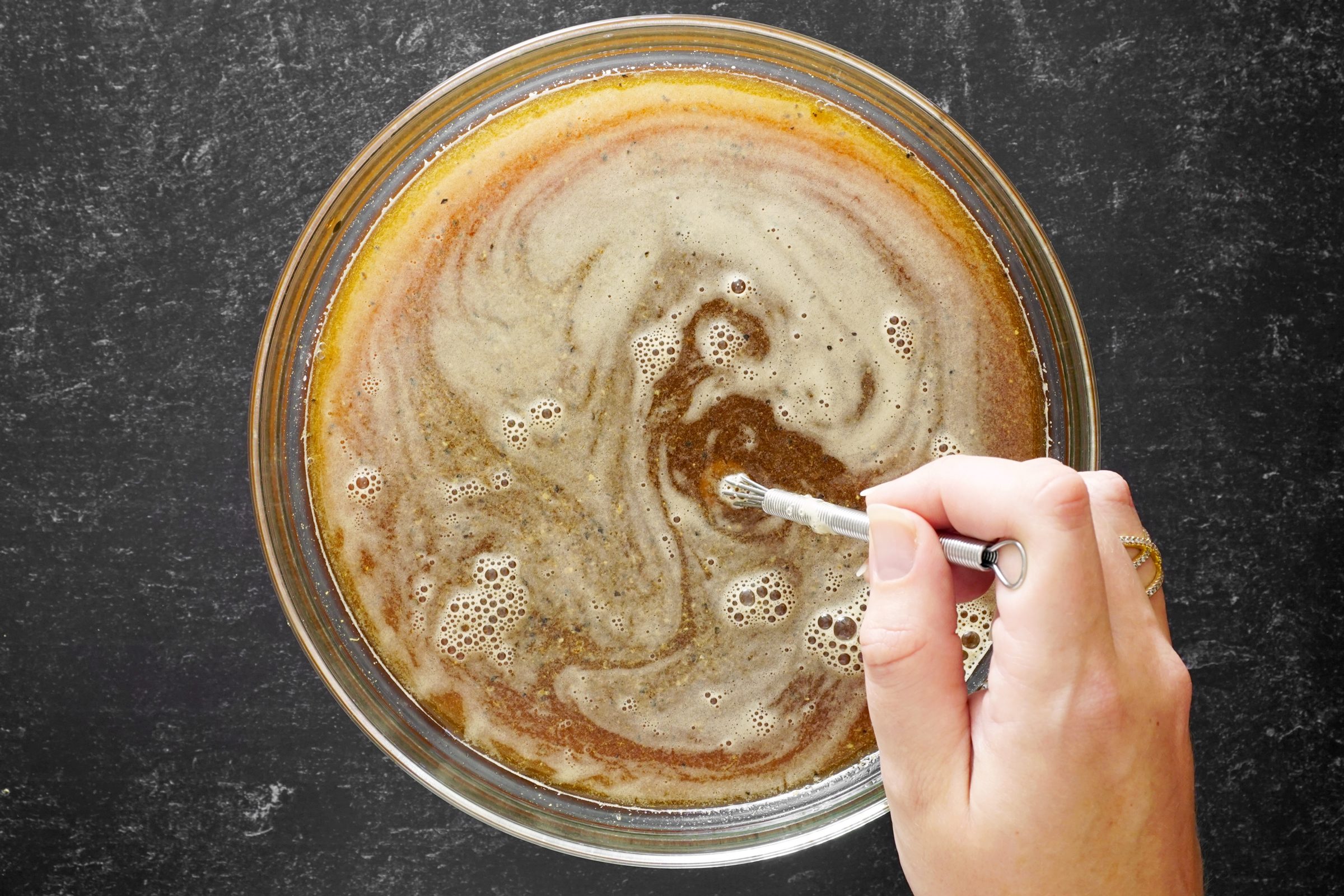 mixing marinade for turkey in a clear glass bowl, top view