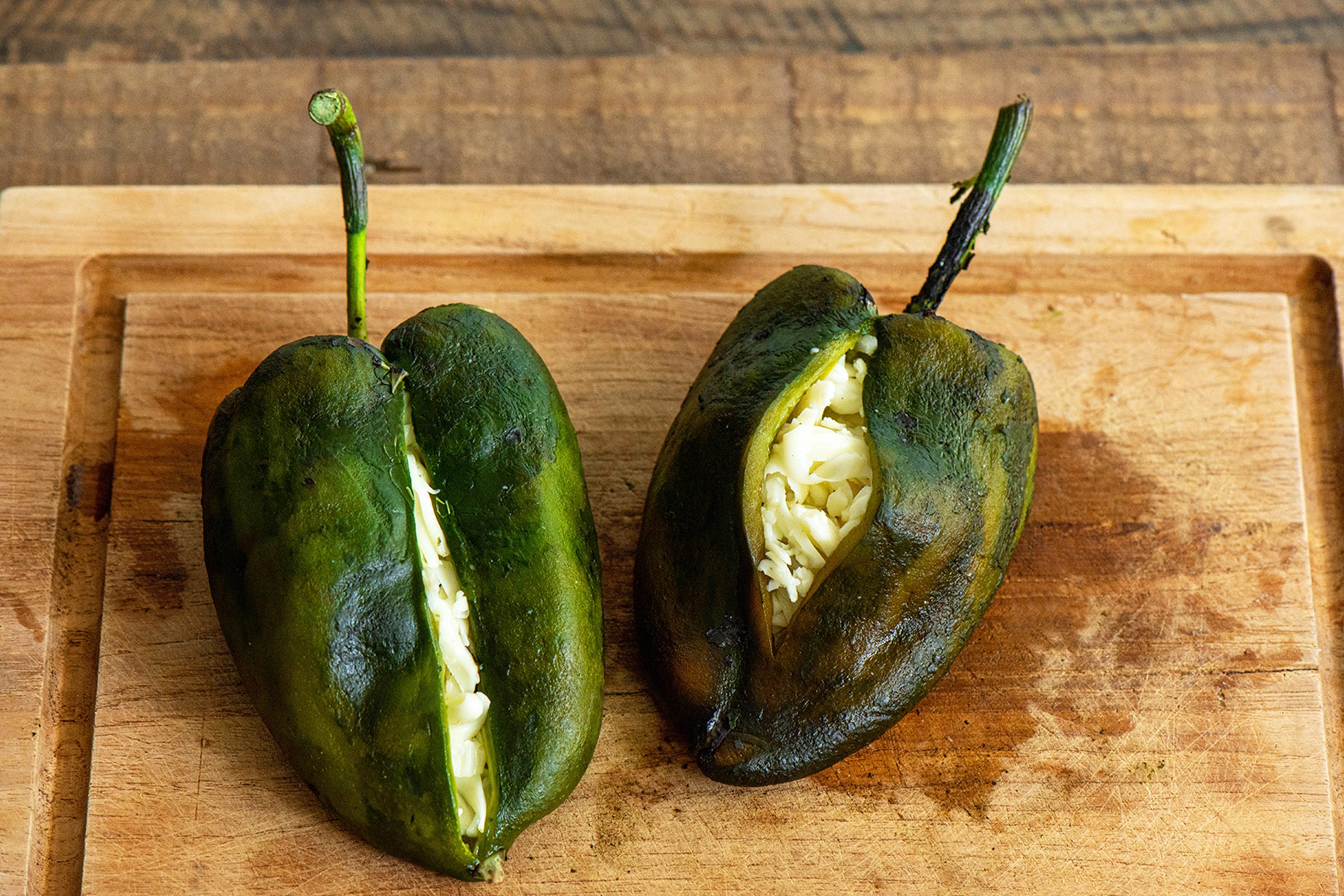 Stuffed Poblano Chiles on wood cutting board