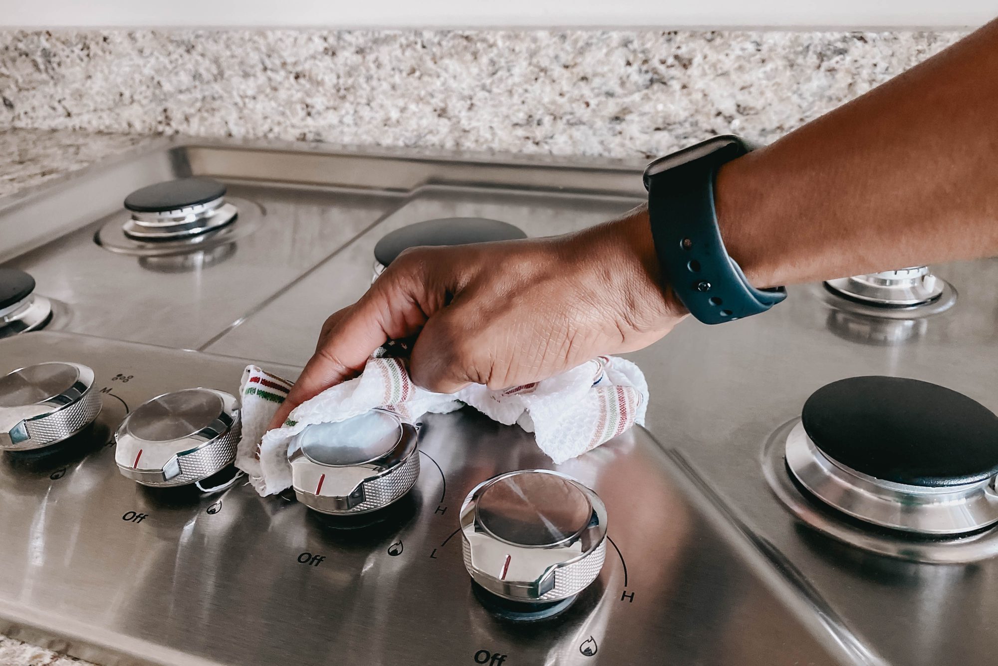 Cleaning and polishing stainless steel oven with a towel
