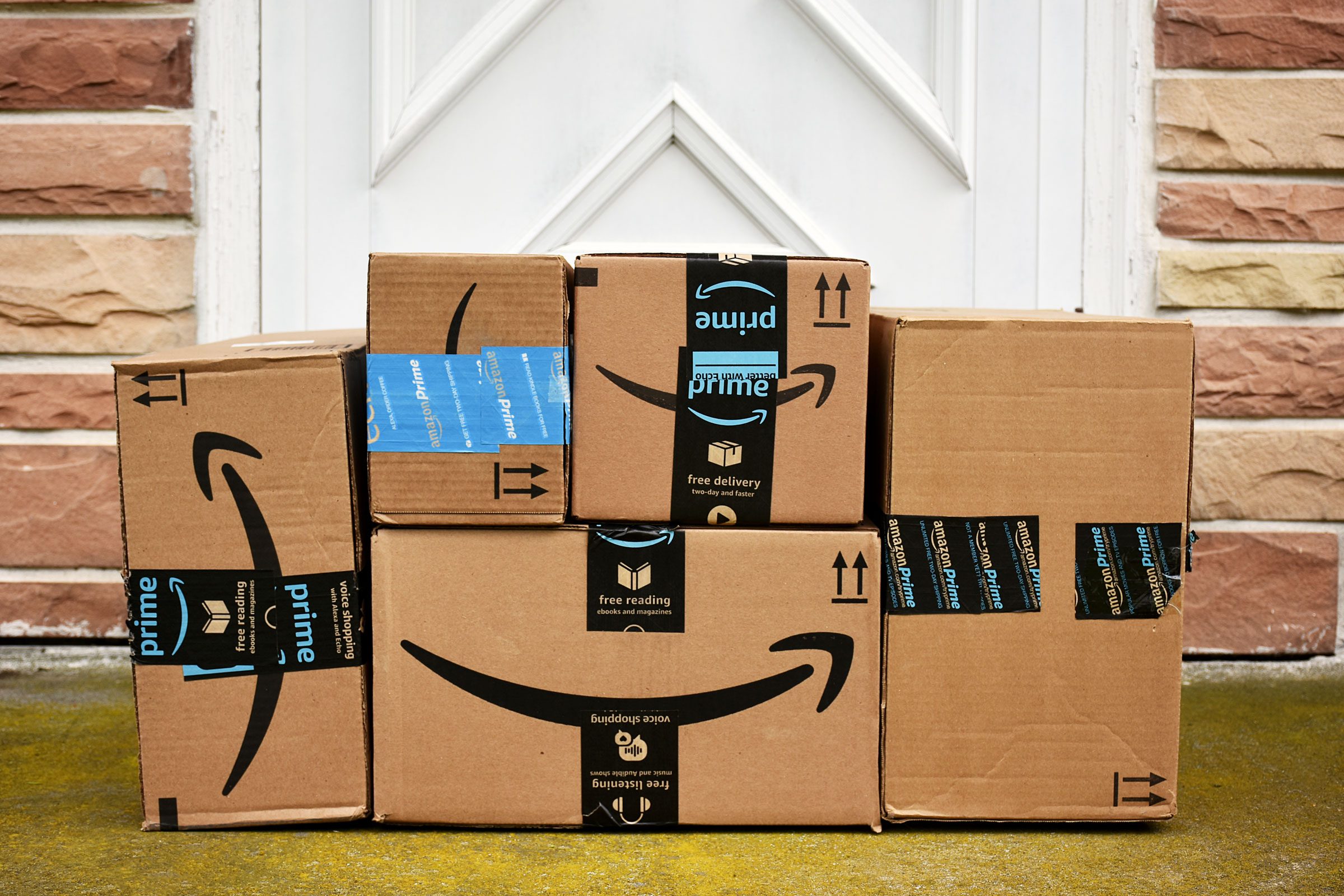 Amazon Prime boxes stacked outside the front door of a home
