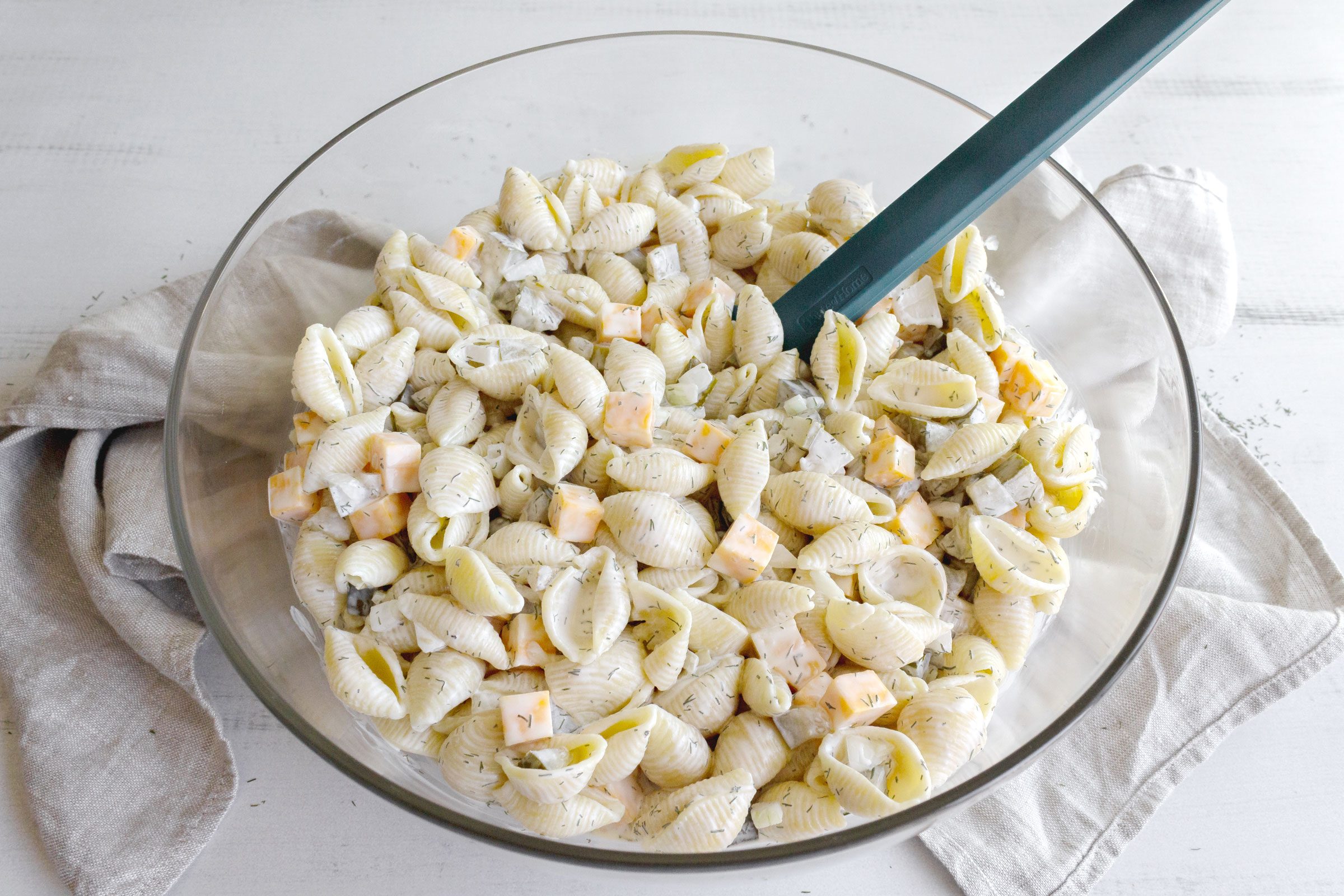 dill pickle pasta salad in a large glass bowl, view from above