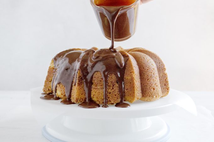 frosting a bundt cake with chocolate ganache