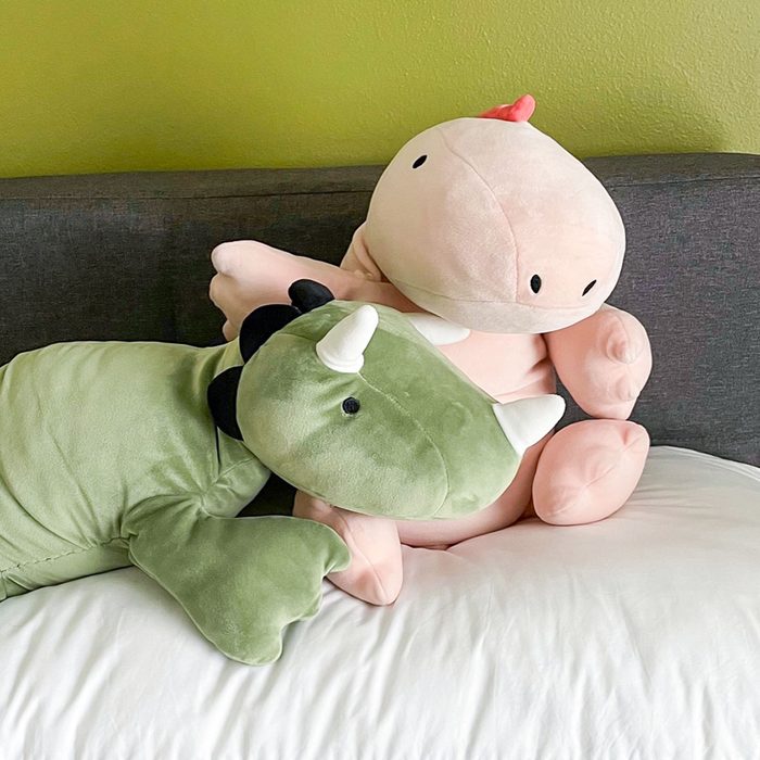Pillowfort plush weighted dinosaurs on bed