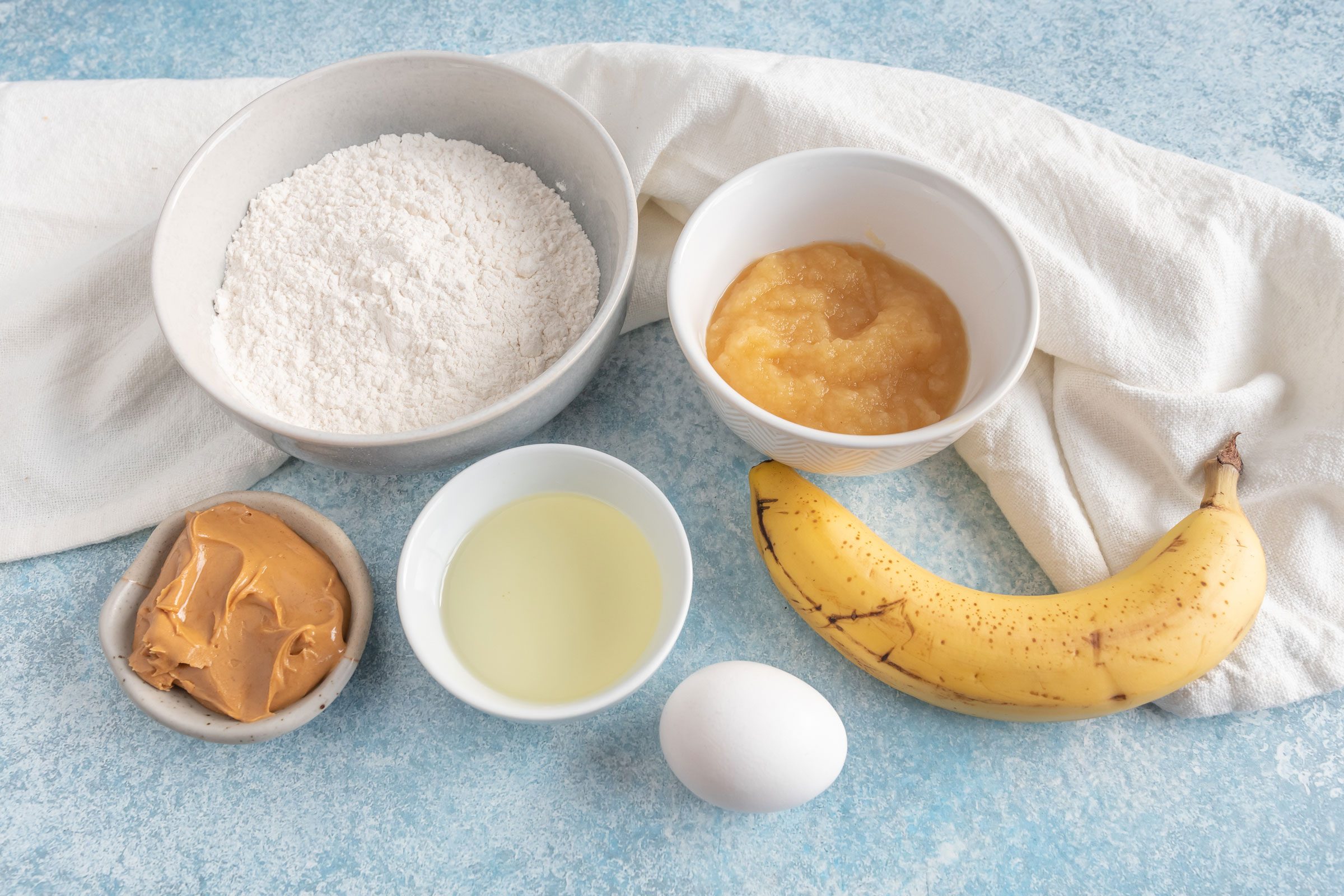 ingredients for dog cupcakes on a blue countertop