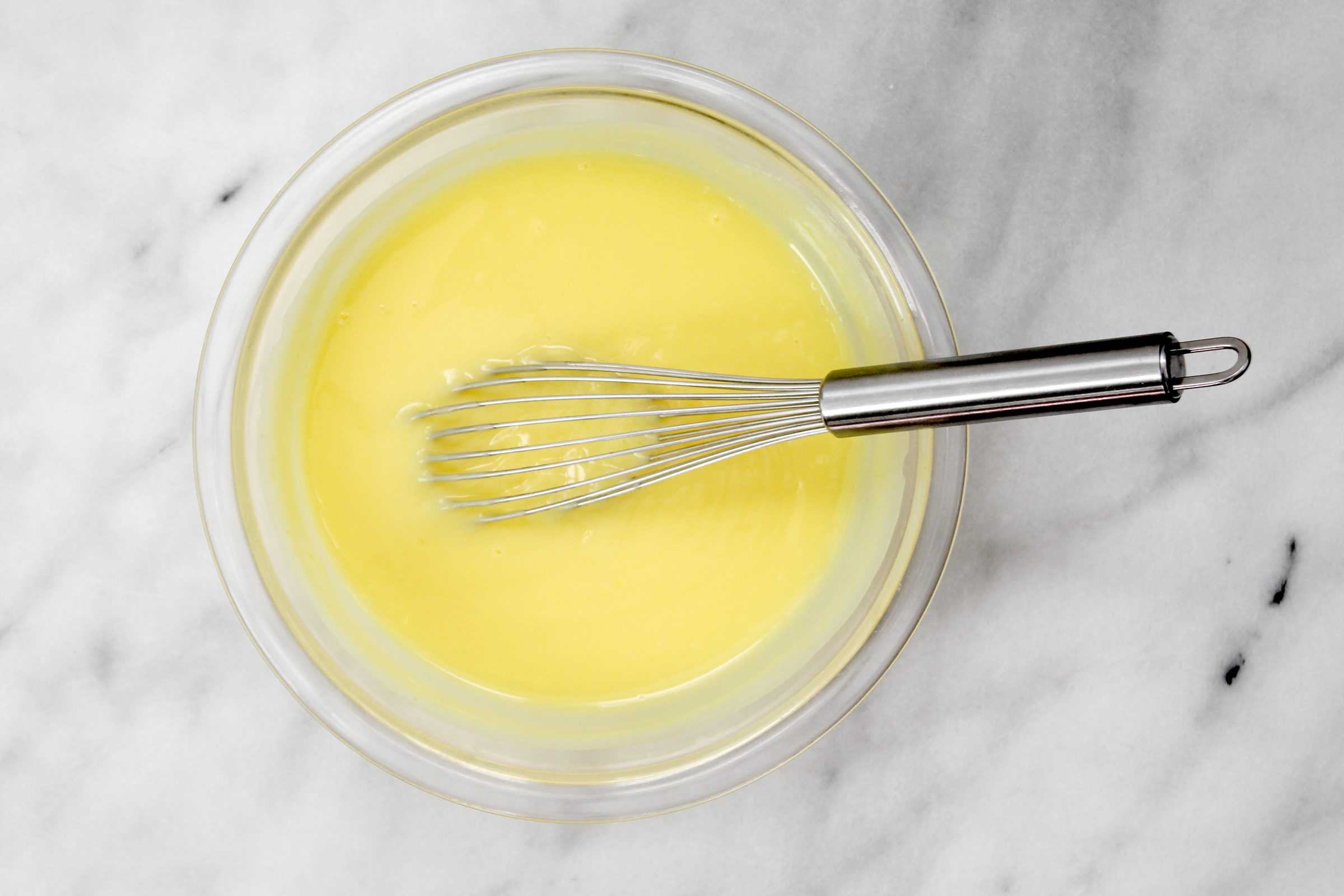 making pudding in a glass bowl with a whisk