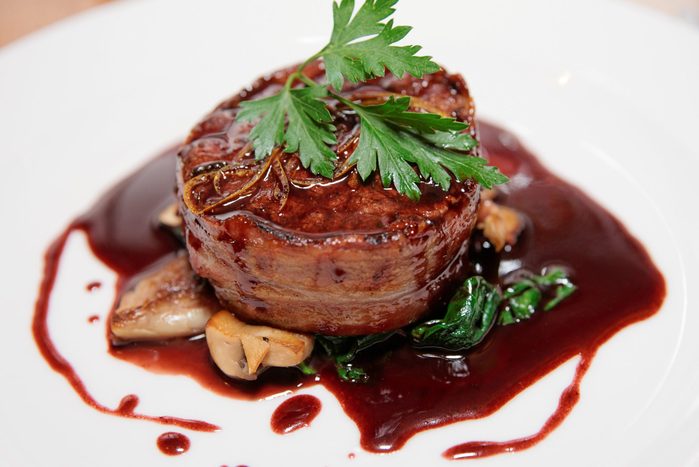 Tenderloin steak wrapped in bacon with red sauce