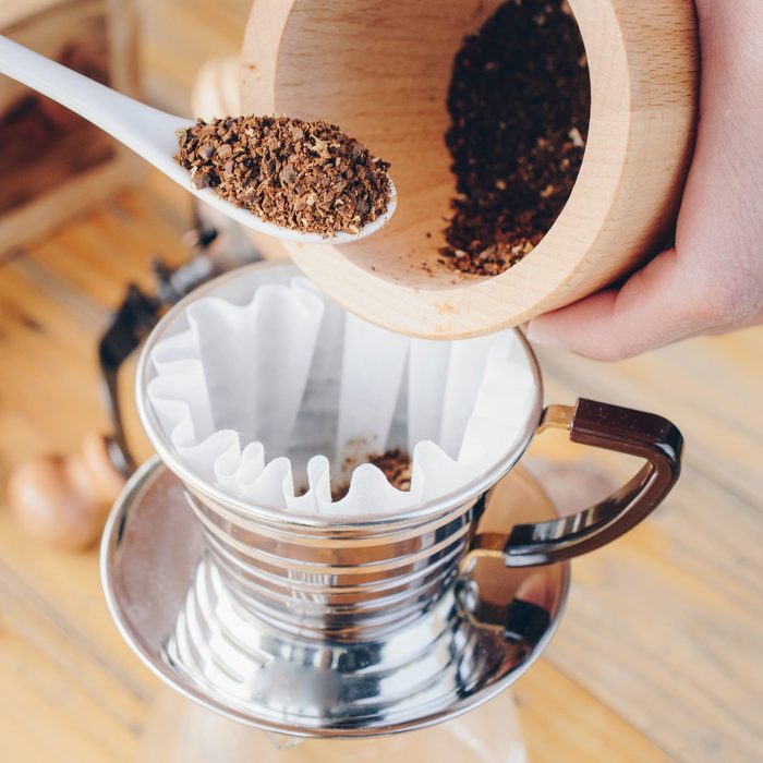 Barista bring the coffee ground powder to the paper filter before brew coffee.