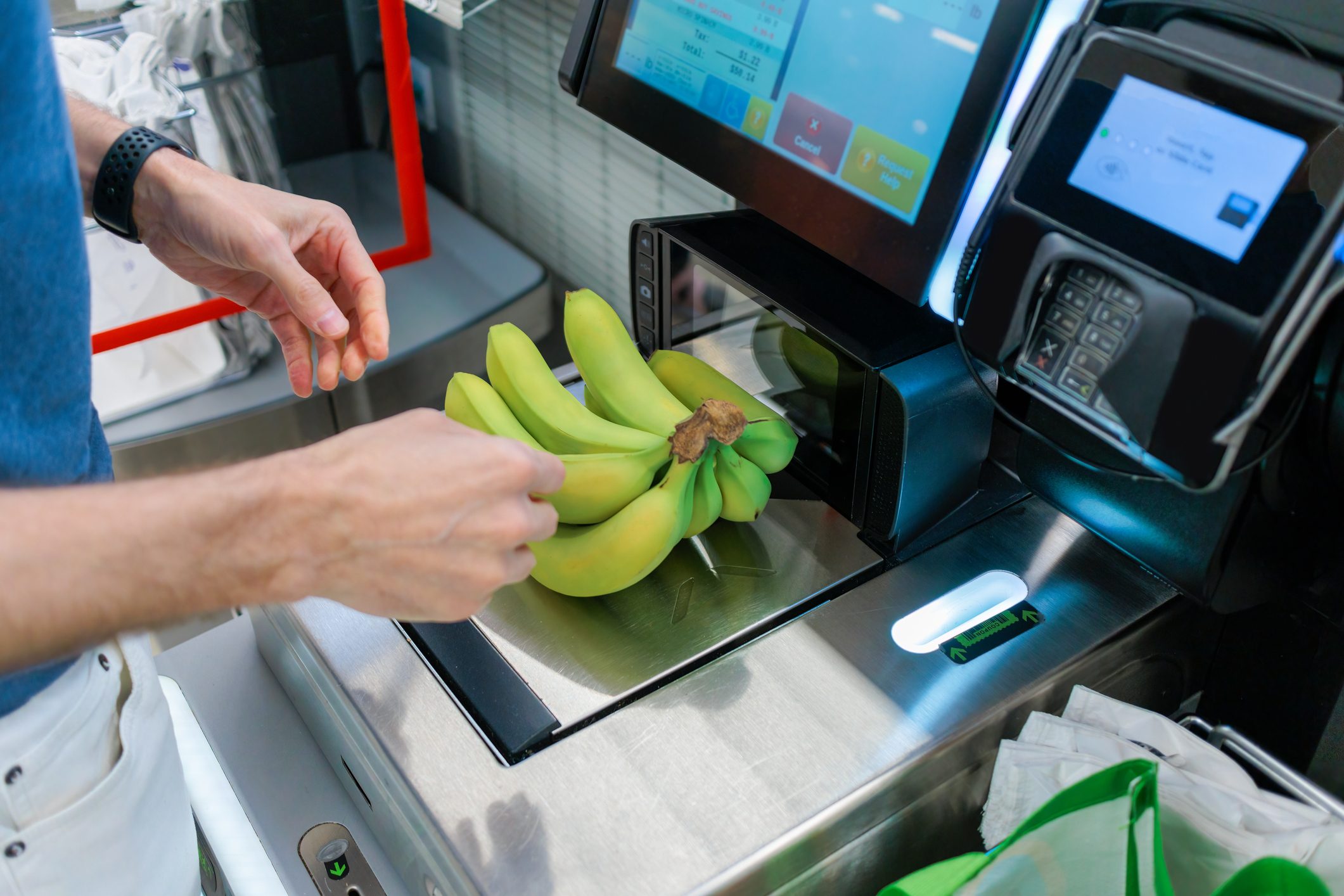 Man Weighs Bananas During Self-Checkout at Supermarket