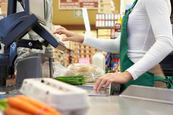 Cashier ringing up groceries at an undisclosed supermarket grocery store