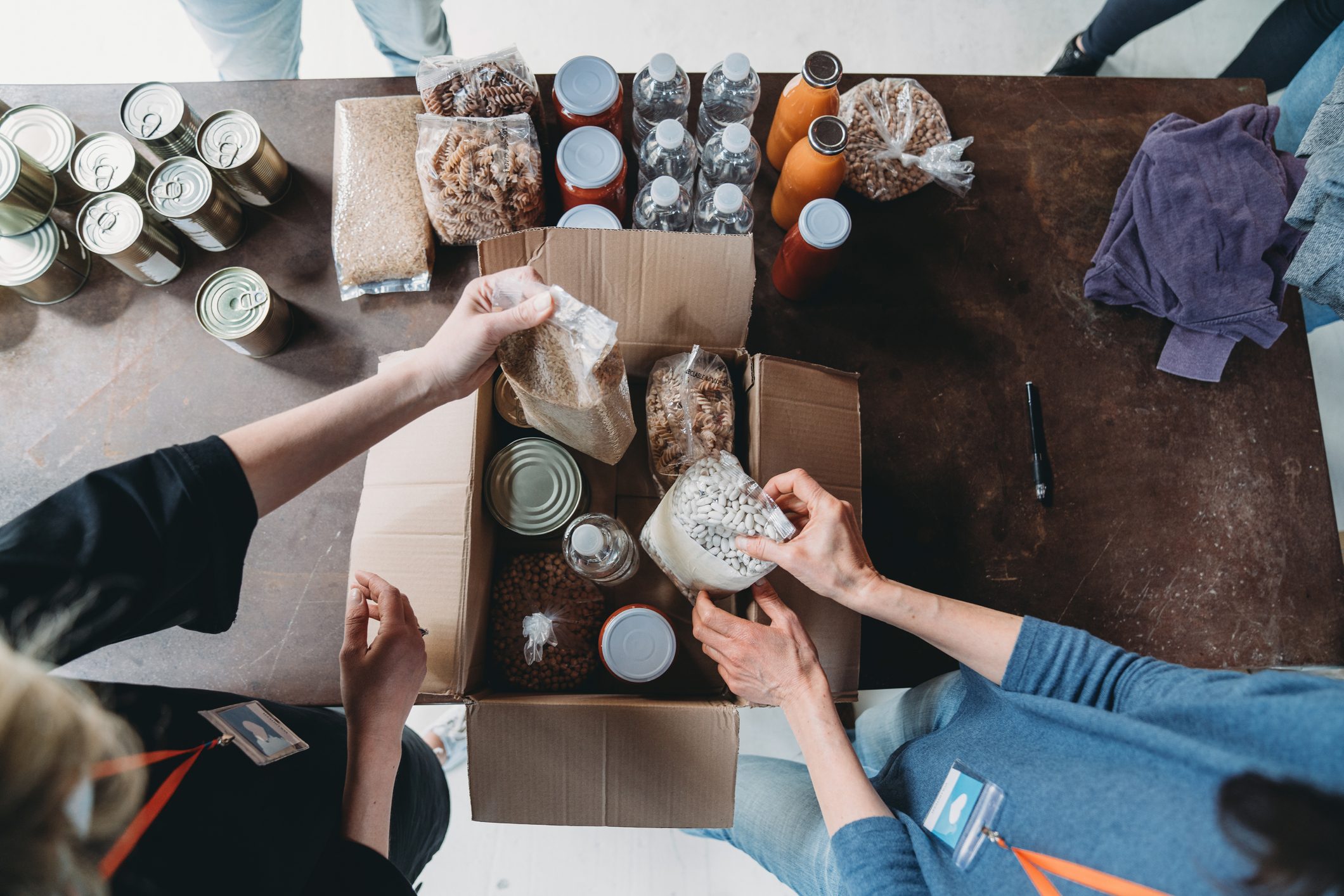 High angle view of volunteers preparing a box of food and drink at the food and clothes bank