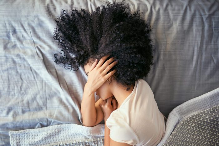 woman with a hangover sleeping in bed
