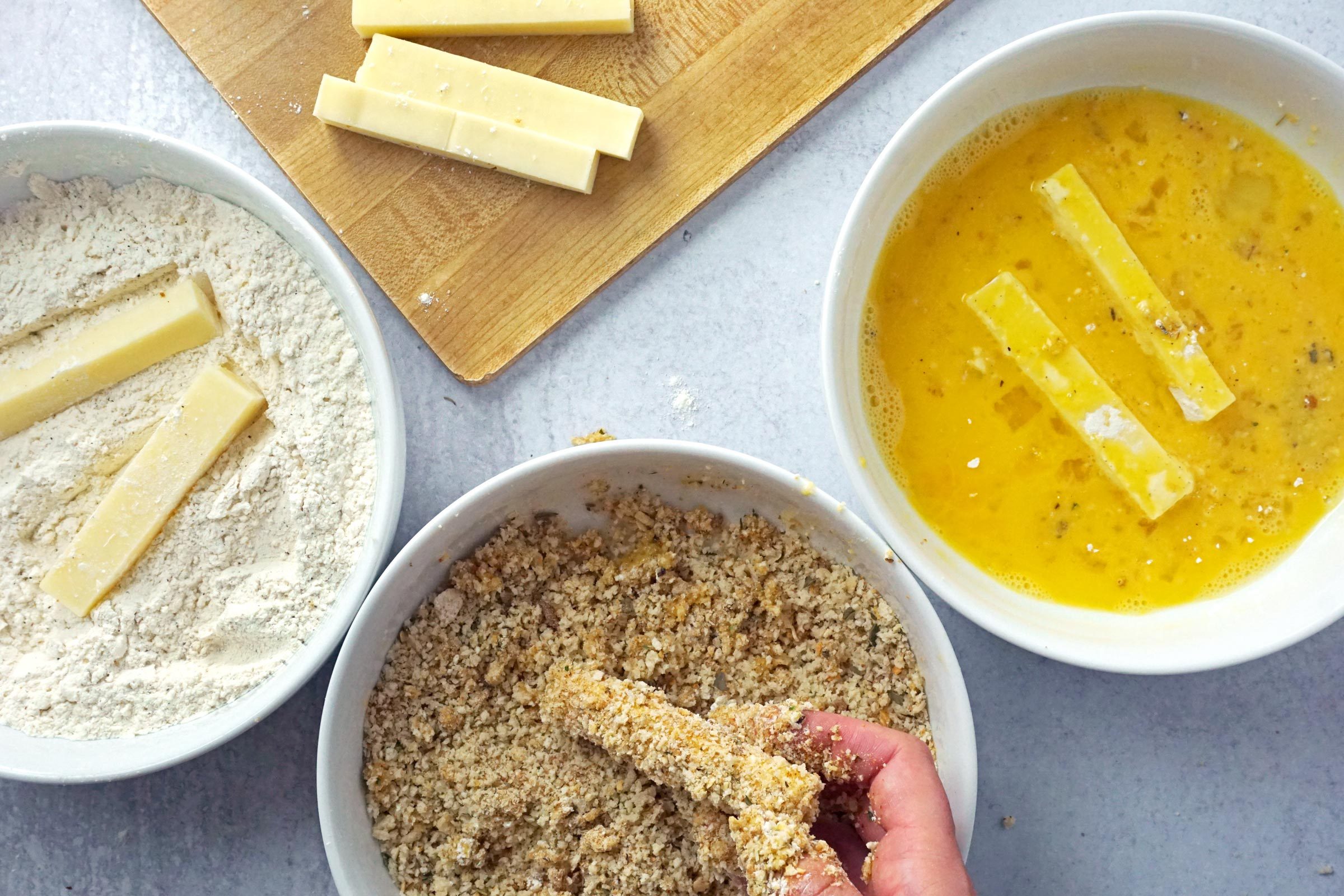 coating Mozzarella sticks in breading