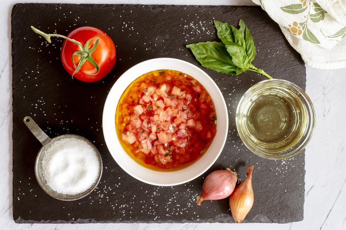 making the sauce in a small white bowl on a slate cutting board