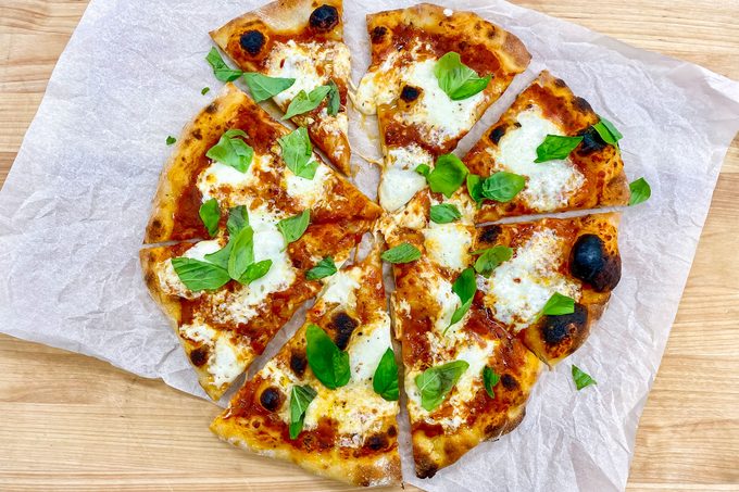 Pizza on paper on wooden surface