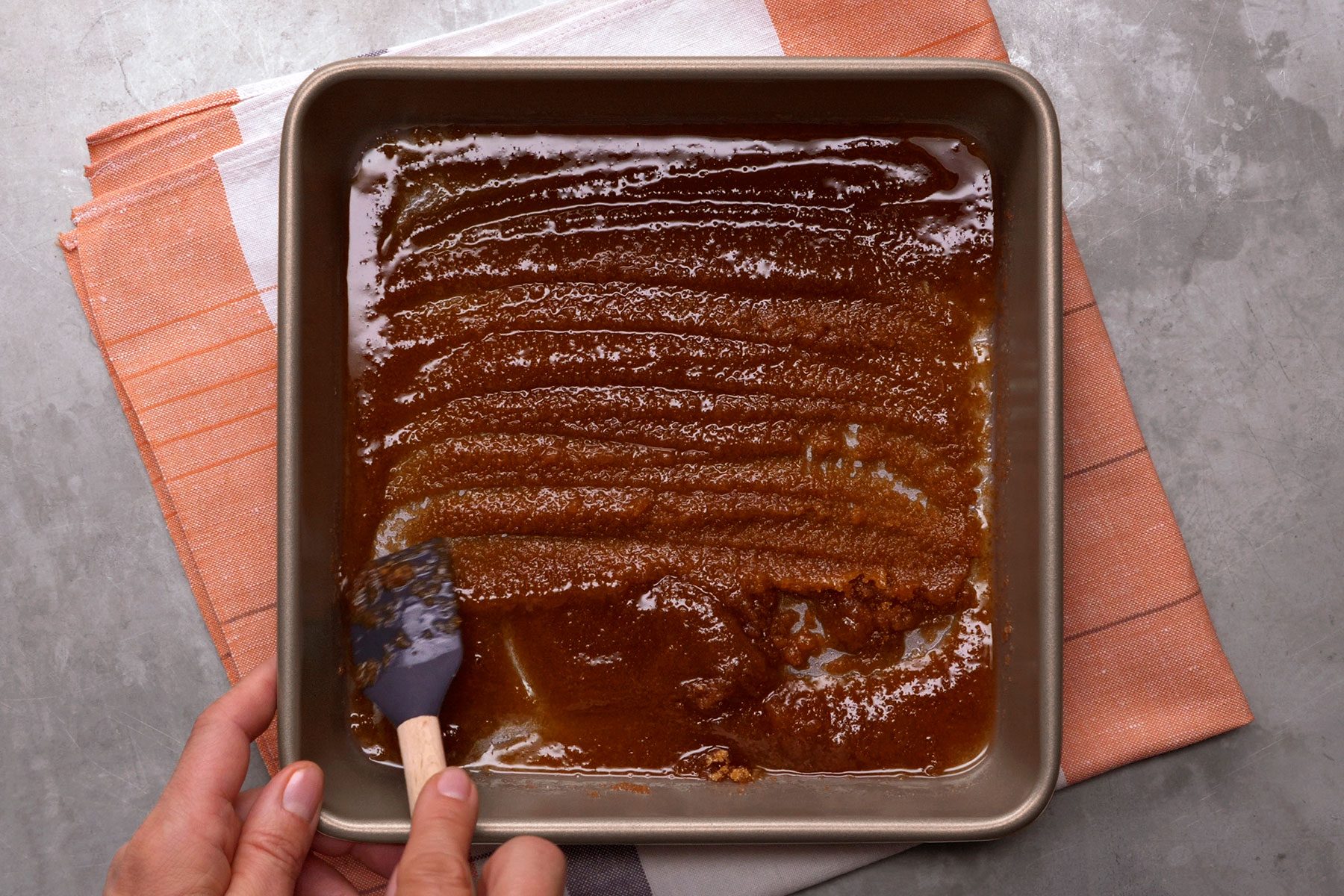Spreading mixture of butter and sugar on pan