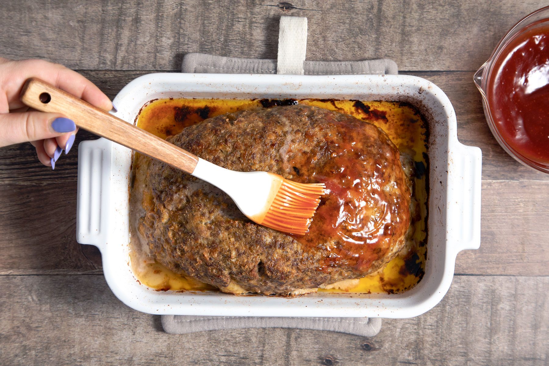 Spreading the sauce over the meat loaf